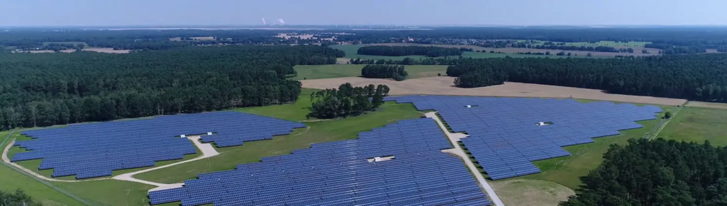 Der Solarpark Frauendorf von SpreeGasSolar aus der Luft betrachtet. Drumherum Wälder.