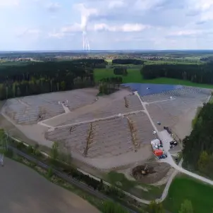 Solarpark Frauendorf aus der Luft. Ein Bagger gräbt eine Grube für die Fundamente des Trafohäuschen.