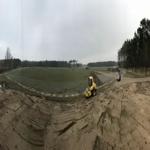Erste Erdbewegungen: Gelbe Walze auf der Freifläche des Solarparks Frauendorf in der Lausitz. Drumherum Wälder.